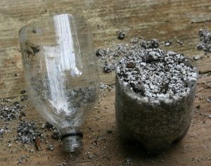Cut a two liter soda bottle in half; make holes in bottom for drainage; fill with media